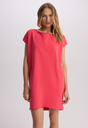 Koronkowa sukienka w kolorze koralowym z krótkim rękawem, luźnym krojem, okrągłym dekoltem i bocznymi kieszeniami; wykonana z miękkiego, gładkiego materiału o prostym designie.