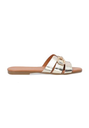 Metallic gold slide sandal featuring three crossed straps, a large buckle detail, and a flat brown sole. Smooth texture overall.