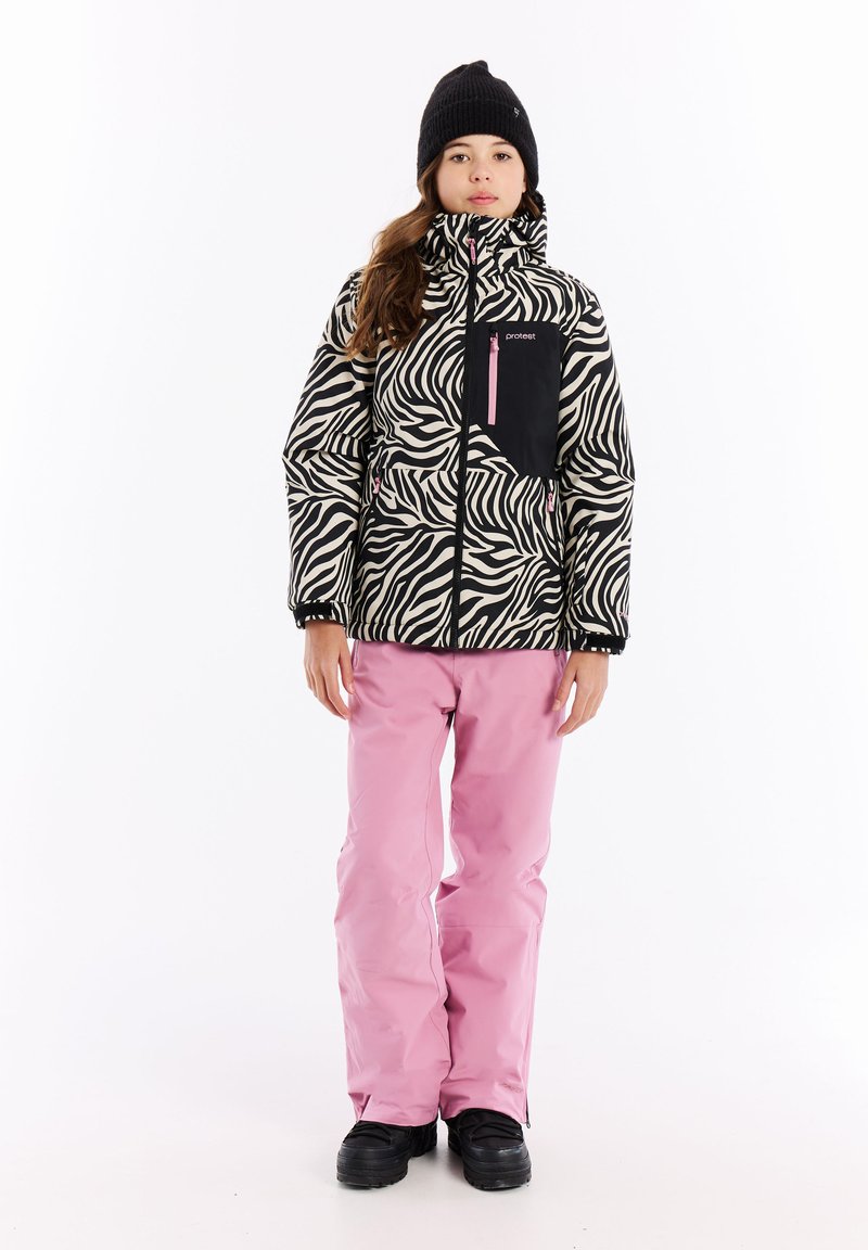 Zebrahunkoisen puhaltimen takki mustassa ja kermaisessa väriyhdistelmässä, jossa on musta rintatasku ja vaaleanpunainen vetoketju; yhdistettynä vaaleanpunaisiin hiihtohousuihin ja mustiin saappaisiin.