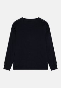 Μαύρο t-shirt με μακριά μανίκια και στρογγυλή λαιμόκοψη, με αντίθετες υφές στις πλάγιες ραφές και εφαρμοστά μανίκια. Μαλακό υλικό με λεία υφή.