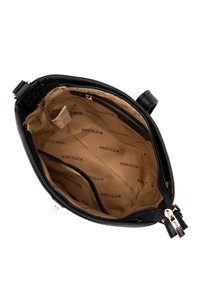 Borsa a tracolla sintetica nera con chiusura a zip, dotata di fodera interna beige con motivo a logo ripetuto e molteplici scomparti per l'organizzazione.