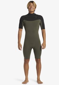 Kortärmad våtdräkt i mörk olivgrön med svarta detaljer. Tillverkad av flexibelt material, med en säker stängning och en kroppsnära design.