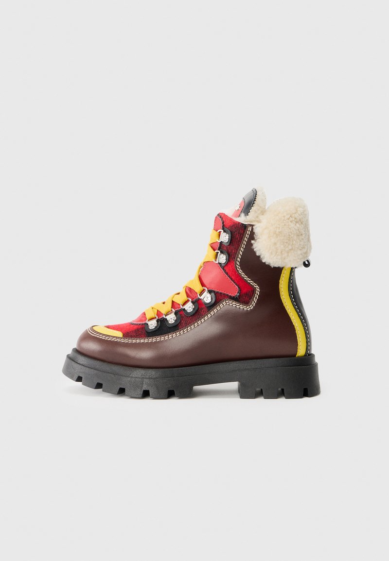 Bruna och röda lädervandringskängor med gula snören, grå pälskrage, texturerad gummisula och metalliska öglor. Flerfärgade designaccenter.