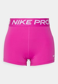 Jasnoróżowe szorty kompresyjne Nike Pro z szerokim pasem, na którym widnieje napis "NIKE PRO", oraz małym białym logo Nike na nodze.
