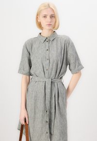 Hallitatud, kraega kleit hallist lina segust lühikeste sleeves, sidumisvöö ja esipaneeli nupudetailidega. Sile tekstuur ja mugav lõige.