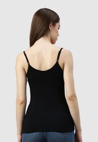 Schwarzes Spaghetti-Top mit verstellbaren Trägern und tailliertem Design, das eine glatte Textur und einen sauberen Abschluss am Saum aufweist.