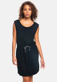 Vestido negro sin mangas con escote redondeado, ceñido a la cintura por un cordón con acentos en blanco contrastantes. Textura suave, a la altura de la rodilla.