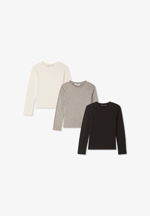 Trzy długie koszule z długim rękawem w kolorach białym, szarym i czarnym. Wykonane z miękkiej tkaniny, z okrągłymi dekoltami, dopasowanym krojem i bez widocznych wzorów czy akcentów.