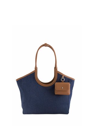 Bolsa tote azul marino con ribetes y asas de cuero marrón, con un pequeño monedero de cuero marrón adjunto con un cierre plateado.