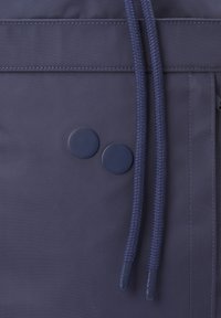 Tissu bleu marine avec deux boutons ronds et cordons tressés munis d'embouts en plastique, coutures visibles en surface.