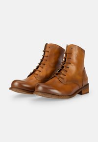 Brown leather ankle boots with a smooth finish, rounded toe, and sturdy laces. Features a low wooden heel and simple stitching details.