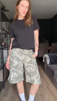 Camouflage cargoshorts in groen en grijs. Gemaakt van lichtgewicht stof, met zijzakken en een relaxte pasvorm. Gecombineerd met een zwart t-shirt.