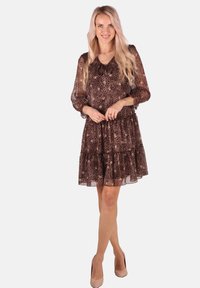 Braun und schwarzes Leopardenmusterkleid mit langen durchsichtigen Ärmeln, V-Ausschnitt und einem gestuften Rock. Hergestellt aus leichtem, strukturiertem Stoff.