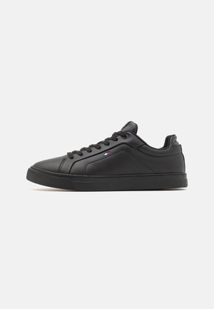 Czarne niskie sneakersy wykonane z gładkiej skóry, z okrągłym noskiem, sznurowanym zapięciem i teksturowaną gumową podeszwą. Oprócz tego mają mały detal w postaci logo.
