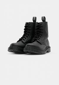 Black leather combat boots with a round toe, reinforced sole, and texted pull tab. Features a lace-up design and textured upper.