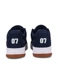 Granatowe sneakersy z teksturowanej zamszowej i siateczkowej cholewki, biała gumowa podeszwa, brązowa gumowa podeszwa zewnętrzna oraz liczba "07" wydrukowana na pięcie w kolorze białym.