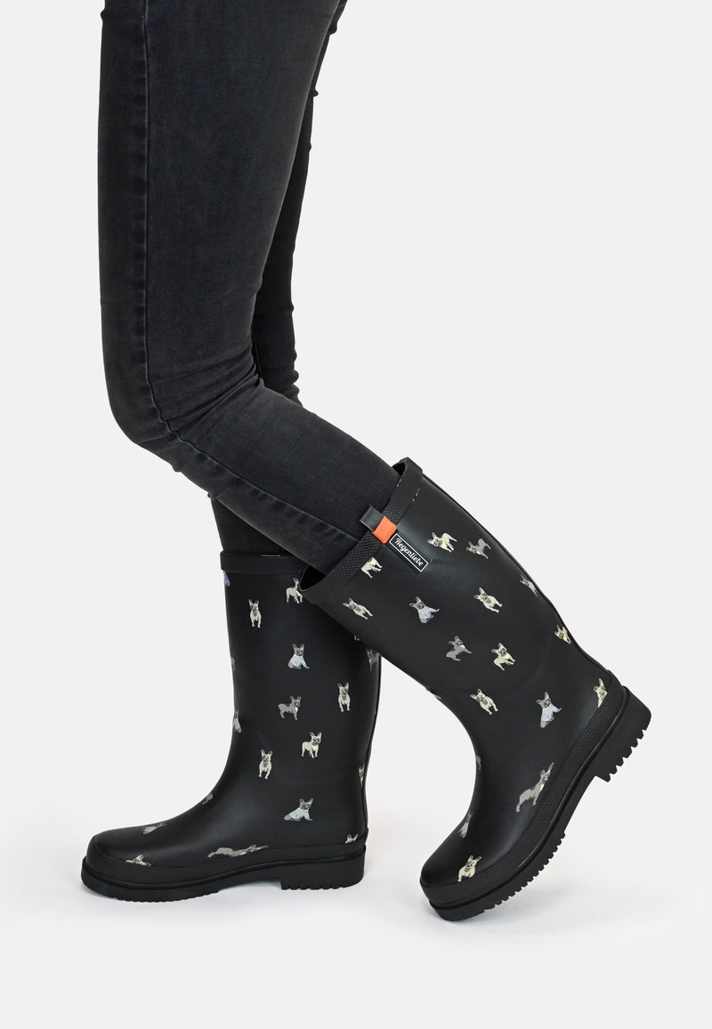 Black rubber rain boots featuring a dog pattern in various colors, textured sole, and a solid black upper with a bright orange accent.