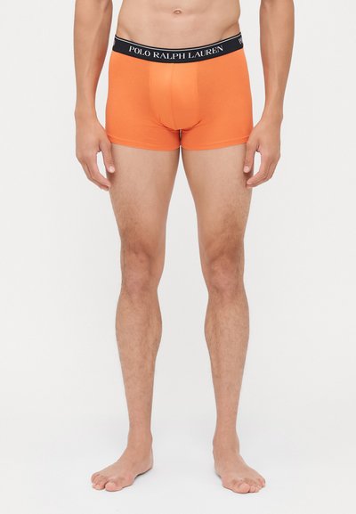 Boxer in cotone arancione con elastico nero in vita che presenta il logo "POLO RALPH LAUREN". Tessuto liscio, design aderente e gambe corte.
