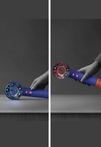 Handhållen enhet med blå och röd färgsättning, slät texturerad handtag, cirkulära kontroller och uttalade cirkulära LED-indikatorer.