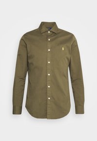 Camicia a maniche lunghe verde oliva in cotone. Presenta un colletto con bottoni, bottoni frontali e un piccolo logo giallo sul lato sinistro del petto.