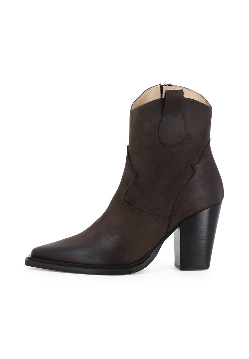 Stivale alla caviglia in suede marrone con punta affusolata, tacco a blocco di 3 pollici, cuciture decorative sul gambale e chiusura con zip sul retro.