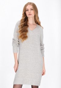 Rochie tricotată gri deschis, cu guler în V, mâneci lungi și tiv striat. Textură moale cu o croială ușor supradimensionată.