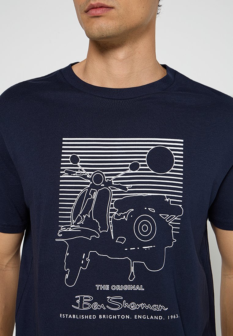 T-shirt bleu marine avec un design graphique blanc d'un scooter, orné de rayures horizontales et d'accents circulaires, fabriqué en coton doux.