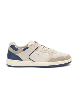 Baskets en suède beige clair avec des accents en cuir bleu marine, bout arrondi et fermeture à lacets. Comprend des détails perforés et une semelle en caoutchouc.