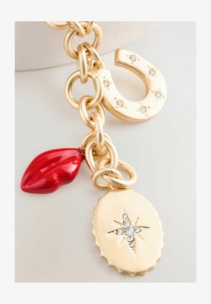 Collana d'oro con maglie circolari, un ciondolo a forma di ferro di cavallo con strass, una forma di labbro rosso lucido e un pendente ovale con un design a stella e pietre.