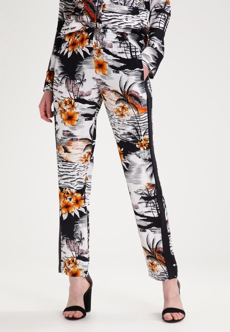 Pantalons à motif floral noir et blanc avec des accents orange, coupe fuselée et rayures latérales ; tissu léger au toucher doux.