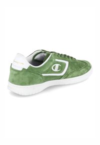 Zöld velúr sneaker fehér részletekkel, kerek orral, ívelt dizájnnal és texturált felülettel. Az oldalán és a sarkán logó található. Gumi talp.