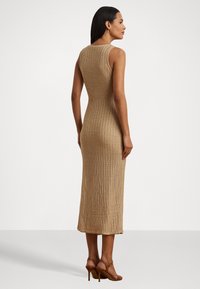 Vestido midi de punto en marrón claro, con una forma ajustada y una textura sutil. Terminado con un dobladillo recto y un diseño sin mangas.