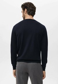 Sudadera azul marino con mangas largas y cuello redondo. Presenta puños y dobladillo acanalados, fabricada en una tela suave y texturada.