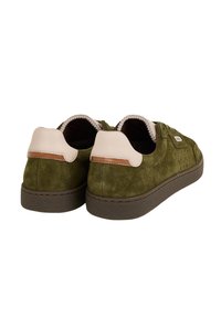 Zapatillas de ante verde con acentos de cuero beige y marrón, puntera redonda, suelas de goma planas y detalles perforados en los laterales.