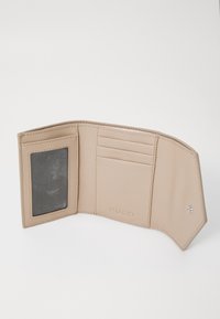 Portefeuille en cuir beige avec une finition texturée, six emplacements pour cartes et une fenêtre ID transparente. Présente un logo embossé et un intérieur lisse.