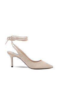 Scarpa slingback in suede beige con punta affusolata e tacco sottile. Presenta una fascia alla caviglia con lacci e una superficie liscia. Suola nera in contrasto.