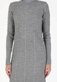 Gray knitted dress with long sleeves, featuring a ribbed texture and subtle pattern. Designed with a round neckline and wrist cuffs.