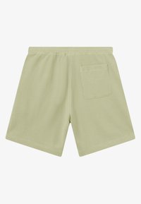 Short en vert clair texturé avec une taille élastique et une poche carrée unique à l'arrière côté droit, posé à plat sur un fond blanc.