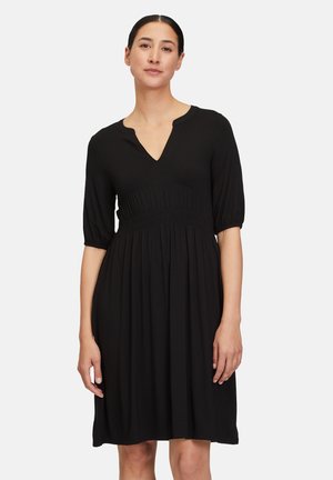 Abito nero con scollatura a V, maniche corte a sbuffo e vita arricciata. Tessuto morbido, lunghezza al ginocchio e gonna fluida. Design semplice e classico.
