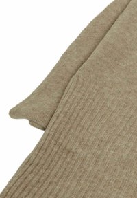 Maglione lavorato a maglia in un beige chiaro, caratterizzato da una texture a coste. Le maniche si allungano con una leggera curvatura e sono realizzate in un materiale morbido e leggero.
