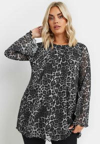 Transparent svart och grå leopardmönstrad topp med långa, volangärmar och rundad halsringning; lättviktsmaterial och flytande silhuett.