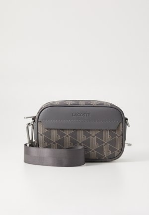 Szara torebka typu crossbody w wzory z teksturowanym wykończeniem, z gładkim szarym paskiem i srebrnym zamkiem błyskawicznym. Logo marki wytłoczone z przodu.