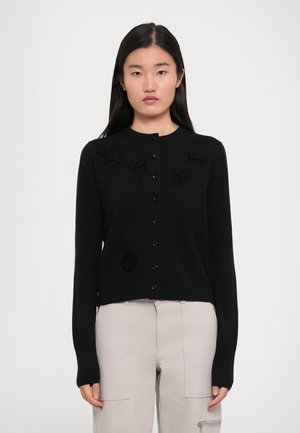 Schwarze Strickjacke aus weichem Material, mit floralem Applikationen in dunklerer Farbe, Rundhalsausschnitt und sechs-knöpfiger Vorderseite.