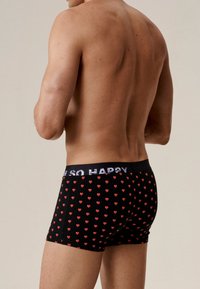 Czarne bokserki z czerwonymi wzorami serc i pasem w talii z napisem "I'M SO HAPPY". Charakteryzują się dopasowanym krojem oraz miękkim, elastycznym materiałem.