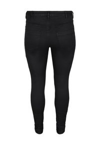 Svarta denim skinny jeans med en åtsittande silhuett, som har två bakfickor och en jämn yta. Midjan är i standardhöjd.