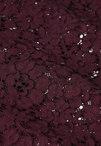 Bordeaux-Spitzenstoff mit floralen Mustern, filigranen Ausschnitten und einer strukturierten Oberfläche, geeignet für die Gestaltung von Bekleidung oder Accessoires.