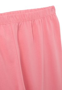 Tejido elástico de color rosa claro con una cinturilla elástica, presentando una textura suave y un diseño simple sin patrones o acentos adicionales.