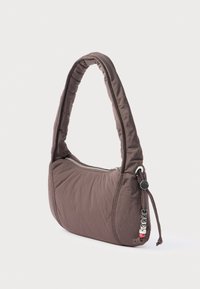 Brown quilted shoulder bag with a curved, padded handle, zip closure, and decorative bead accents on the side. Smooth fabric texture.