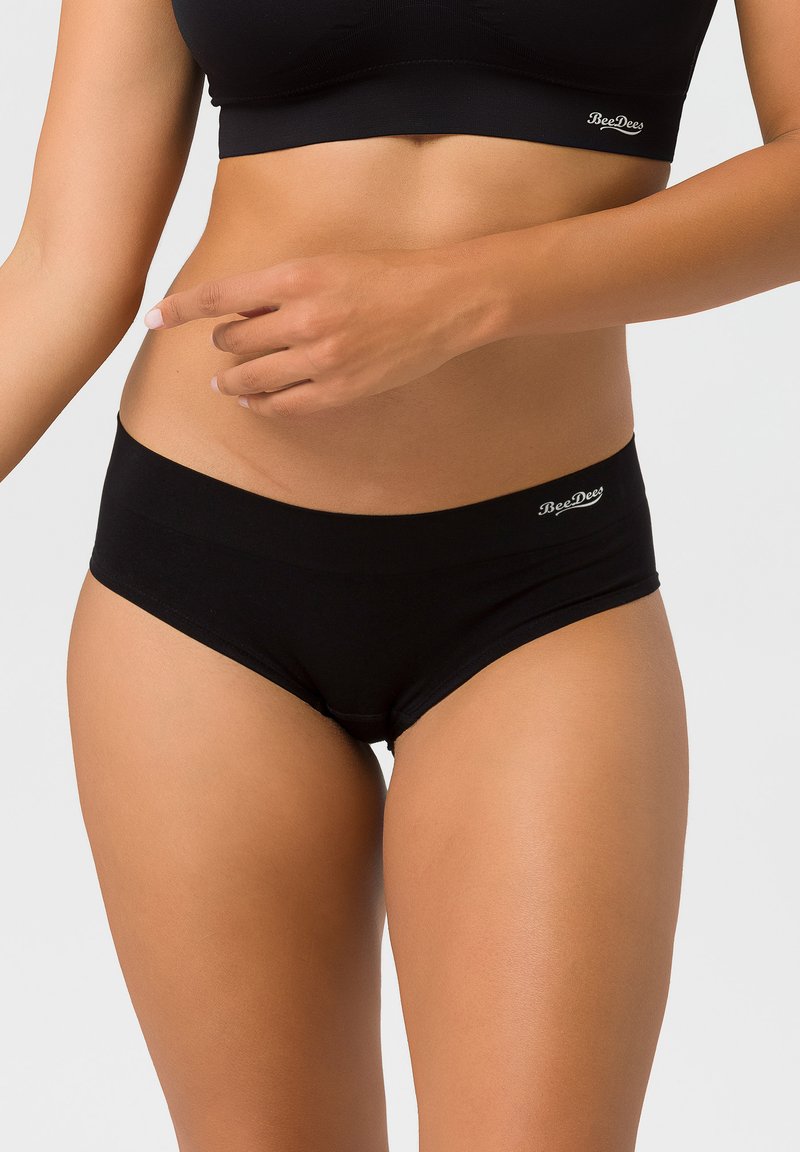 Schwarze Baumwoll-Boyshorts mit glatter Oberfläche, breitem Bund und kleinem Logo-Detail auf der Vorderseite. Weicher Stoff, eng anliegendes Design.