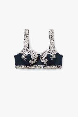 Marineblauer Spitzen-BH mit cremefarbenen Blumenstickereien, Unterbügelunterstützung, gezackten Kanten und verstellbaren Trägern für einen sicheren Sitz.